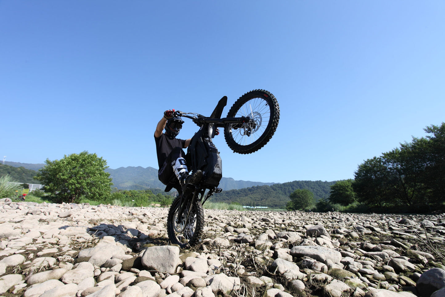 Doing a Wheelie on Black Dirt Bike E Ride Pro SS on rocks